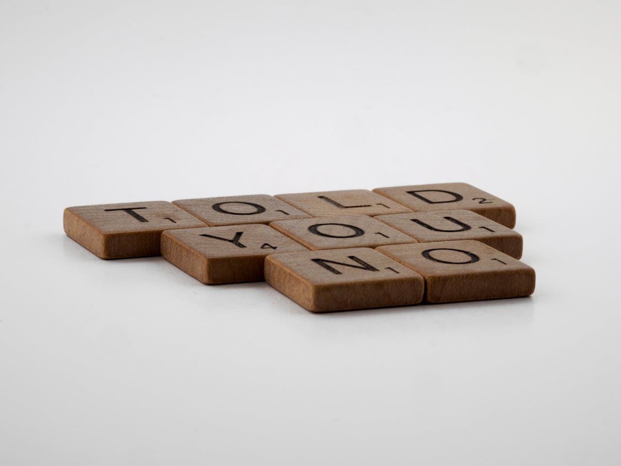 Brown Wooden Scrabble Tiles on White Surface